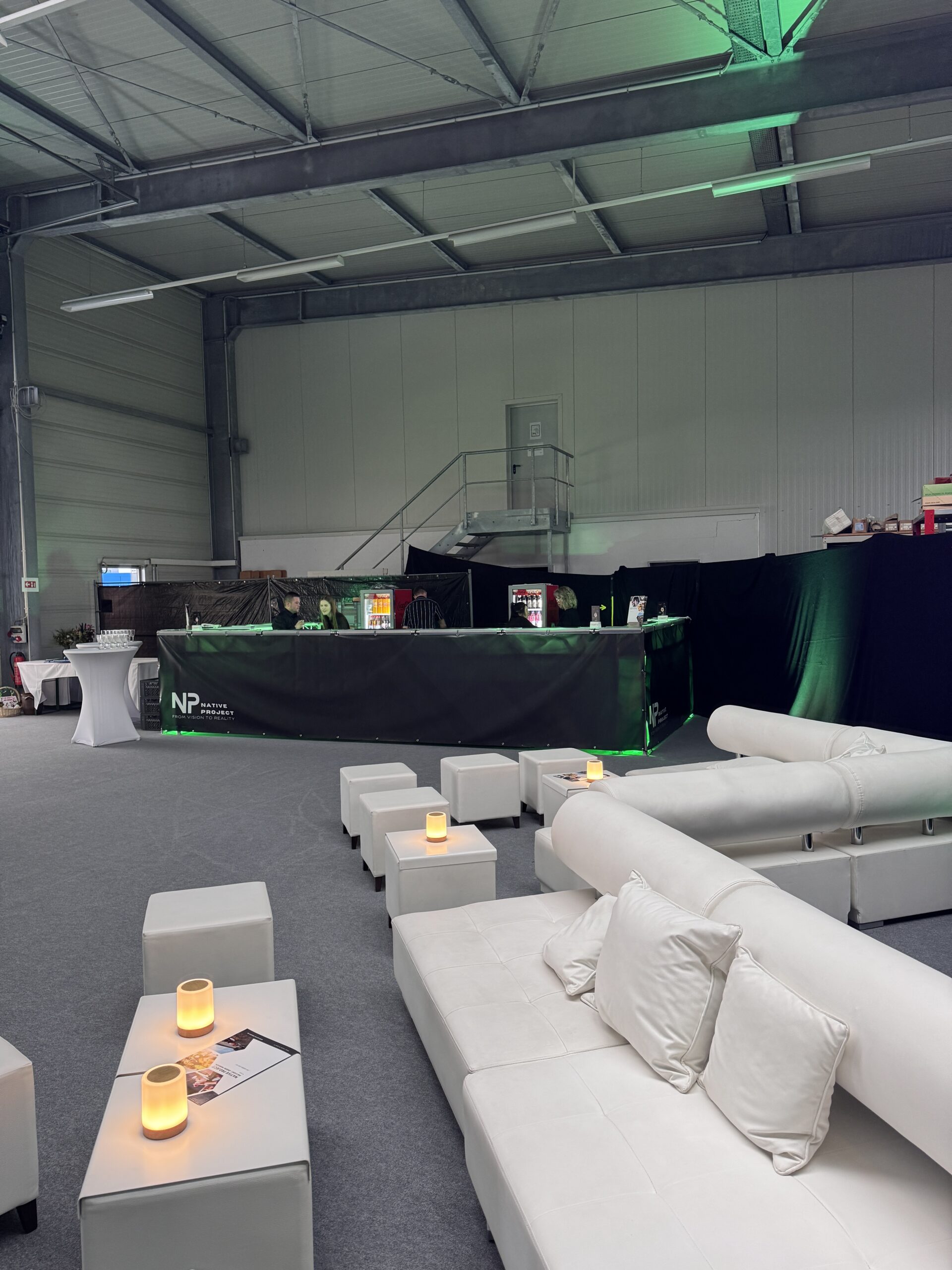 Lounge mit weißen Sofas und Bar in einer Veranstaltungshalle