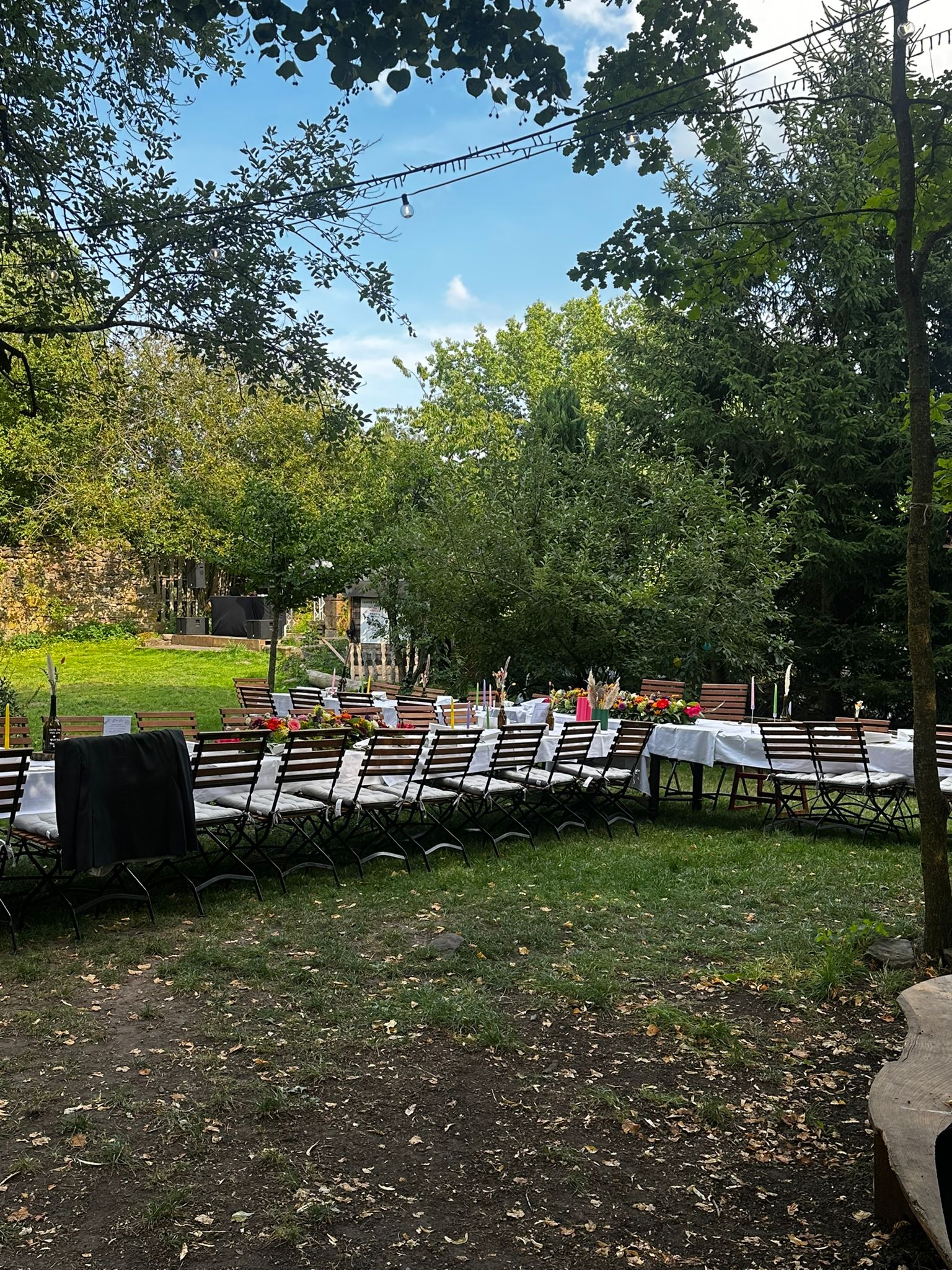 Gartenfest mit Tafeln unter Bäumen