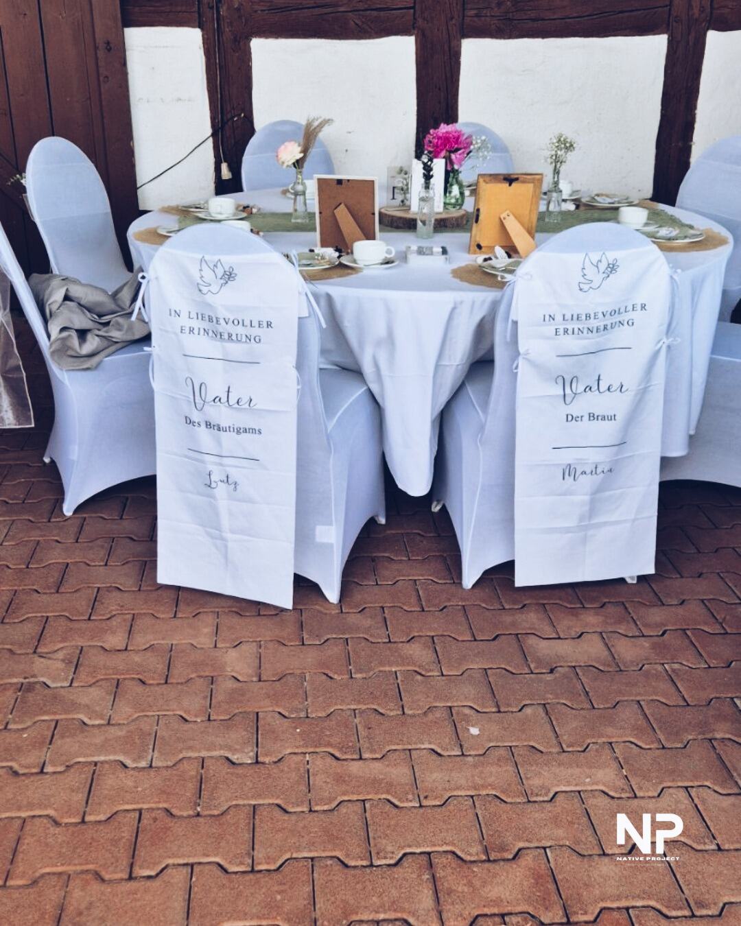 Gedeckte Hochzeitstafel mit Tellern, Gläsern und beschrifteten Servietten